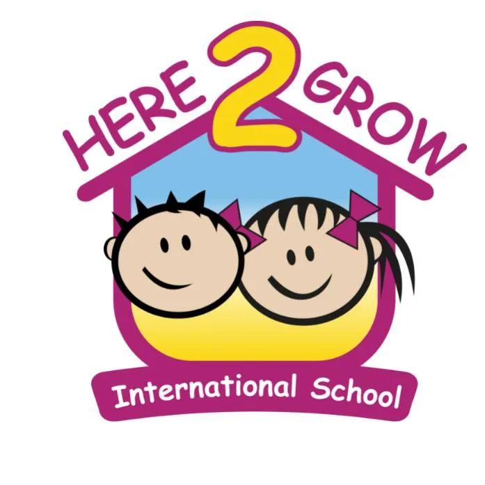 مدرسة هنا لنكبر العالمية - Logo